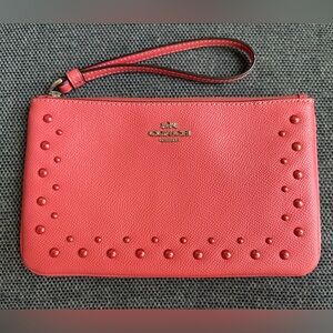 Like new Coach coral wristlet with stud detail